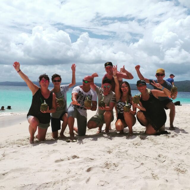 Eine Gruppe fröhlicher Touristen am Strand auf der Bacardi Insel